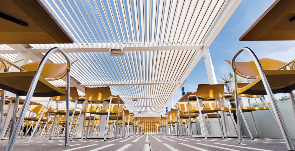 Pérgola bioclimática a proteger o terraço de um restaurante mediterrânico